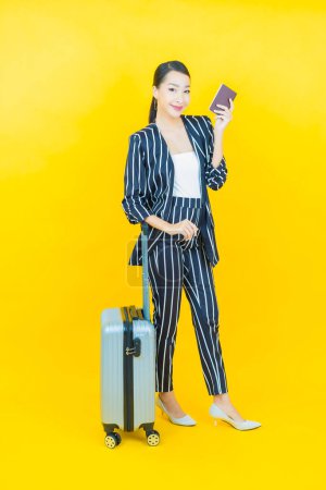 Téléchargez les photos : Portrait belle jeune femme asiatique avec sac à bagages et passeport prêt pour le voyage - en image libre de droit