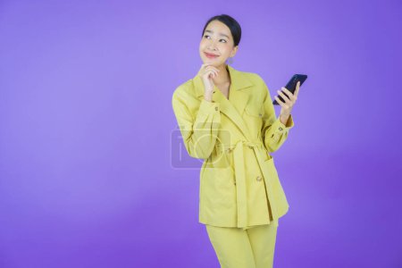 Photo for Portrait beautiful young asian woman smile with smart mobile phone on color background - Royalty Free Image