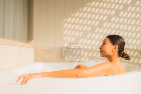 Foto de Retrato joven asiática mujer relajarse tomar un baño en bañera para spa concepto - Imagen libre de derechos