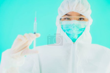 Téléchargez les photos : Portriat belle jeune asiatique médecin femme avec seringue vaccin pour protéger coronavirus ou covid19 sur fond bleu isolé - en image libre de droit