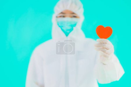 Photo for Portrait beautiful young asian doctor woman wear ppe or  personal protective equipment for protect from coronavirus or covid19 show heart on blue isolated background - Royalty Free Image