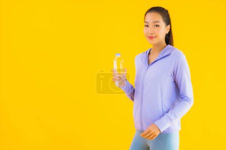 Photo for Portrait beautiful young asian sport woman with sportwear ready for exercise on yellow isolated background - Royalty Free Image