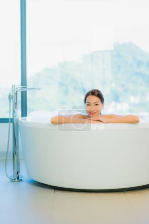 Foto de Retrato hermosa joven mujer asiática relajarse ocio disfrutar en la bañera en el baño y aseo interior - Imagen libre de derechos