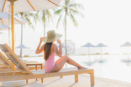 Photo for Portrait beautiful young asian woman relax leisure around outdoor swimming pool with sea beach ocean view in vacation travel - Royalty Free Image