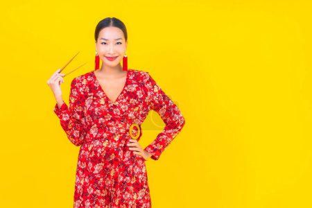 Photo for Portrait beautiful young asian woman with chopsticks on color isolated background - Royalty Free Image