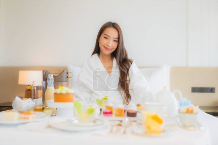 Photo for Portrait beautiful young asian woman enjoy breakfast on bed in bedroom interior - Royalty Free Image