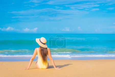 Téléchargez les photos : Portrait belle jeune femme asiatique se détendre sourire loisirs autour de la mer tropicale de plein air plage océan en vacances Voyage - en image libre de droit