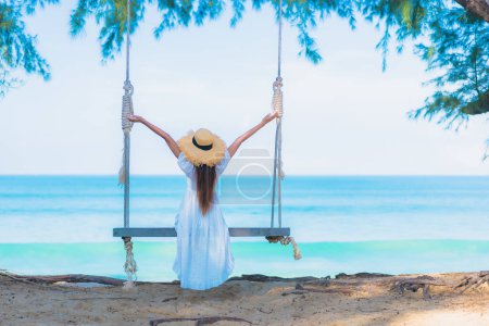 Photo for Portrait beautiful young asian woman relax smile leisure on swing around beach sea ocean with blue sky white cloud - Royalty Free Image