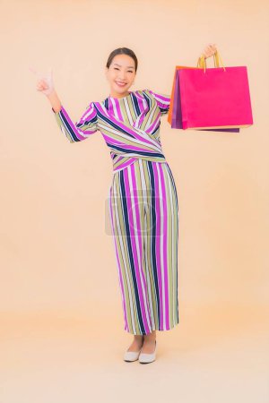 Téléchargez les photos : Portrait belle jeune femme asiatique avec sac à provisions coloré sur fond isolé couleur - en image libre de droit
