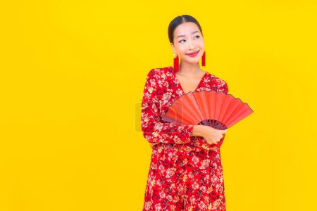 Téléchargez les photos : Portrait belle jeune femme asiatique sourire en action en chinois nouvelle année concept sur fond de couleur - en image libre de droit