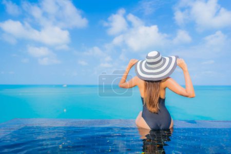Photo for Portrait beautiful young asian woman relax smile leisure around outdoor swimming pool in resort hotel with sea ocean view - Royalty Free Image