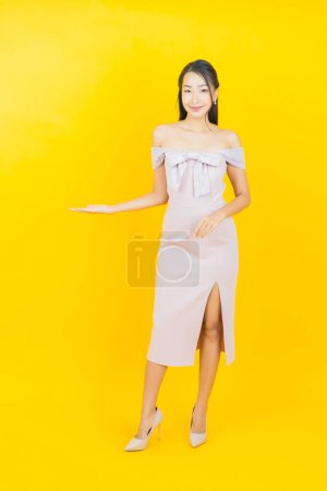 Téléchargez les photos : Portrait belle jeune femme asiatique sourire avec action sur fond de couleur - en image libre de droit
