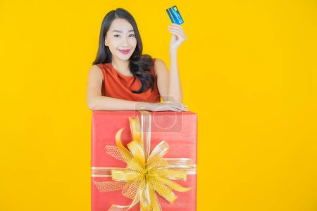 Photo for Portrait beautiful young asian woman smile with red gift box on color background - Royalty Free Image