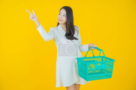 Photo for Portrait beautiful young asian woman smile with grocery basket from supermarket on color background - Royalty Free Image