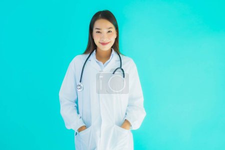Foto de Retrato hermosa joven asiática médico mujer con estetoscopio para su uso en la clínica o el hospital sobre fondo aislado azul - Imagen libre de derechos