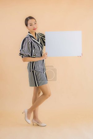 Foto de Retrato hermosa joven asiática mujer mostrar vacío blanco cartel papel para texto y copiar espacio - Imagen libre de derechos