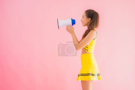 Foto de Retrato hermosa joven asiática mujer animadora con megáfono en rosa aislado fondo - Imagen libre de derechos