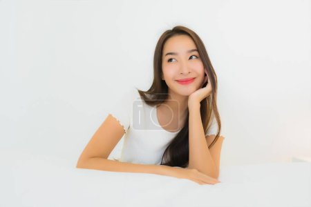Foto de Retrato hermosa joven asiática mujer relajarse feliz sonrisa en la cama con almohada blanca manta interior del dormitorio - Imagen libre de derechos