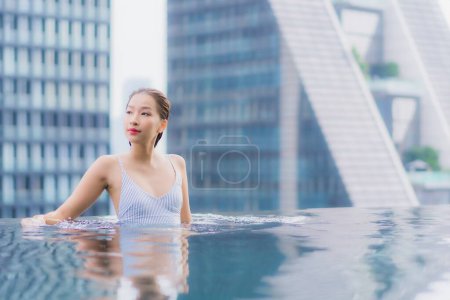 Téléchargez les photos : Portrait belle jeune asiatique femme relax sourire loisirs autour de piscine extérieure dans hotel resort - en image libre de droit