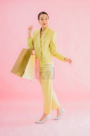Téléchargez les photos : Portrait belle jeune femme d'affaires asiatique avec sac à provisions sur fond isolé couleur - en image libre de droit