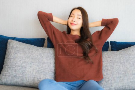 Photo for Portrait beautiful young asian woman relax smile on sofa in living room interior - Royalty Free Image