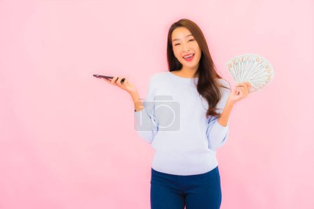 Photo for Portrait beautiful young asian woman with a lot of cash and money on pink color background - Royalty Free Image