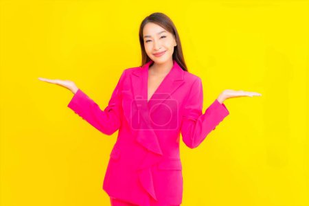Téléchargez les photos : Portrait belle jeune femme asiatique sourire en action sur fond de couleur jaune - en image libre de droit