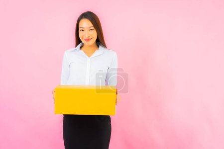 Foto de Retrato hermosa joven mujer asiática con caja de embalaje listo para el envío sobre fondo de color rosa - Imagen libre de derechos
