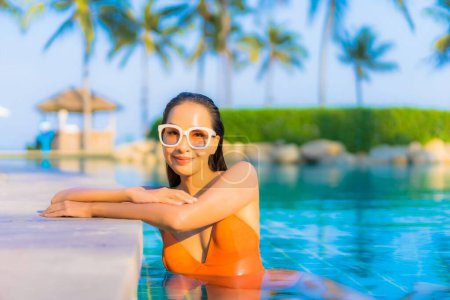 Photo for Portrait beautiful young asian woman relax smile leisure around outdoor swimming pool with sea ocean view - Royalty Free Image