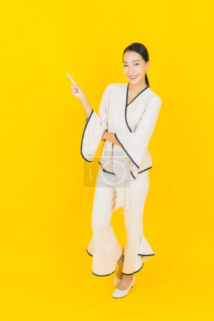Foto de Retrato hermosa joven negocio asiático mujer con sonrisa y acción amarillo fondo - Imagen libre de derechos