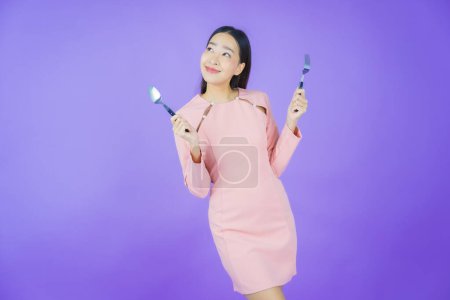 Photo for Portrait beautiful young asian woman smile with spoon and fork on color background - Royalty Free Image