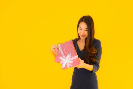 Photo for Portrait beautiful young asian woman with giftbox on yellow isolated background - Royalty Free Image