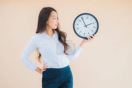 Photo for Portrait beautiful young asian woman show alarm or clock on isolated color background - Royalty Free Image