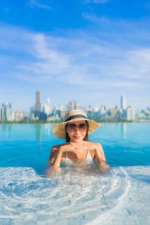 Photo for Portrait beautiful young asian woman smile relax leisure around outdoor swimming pool with city view - Royalty Free Image