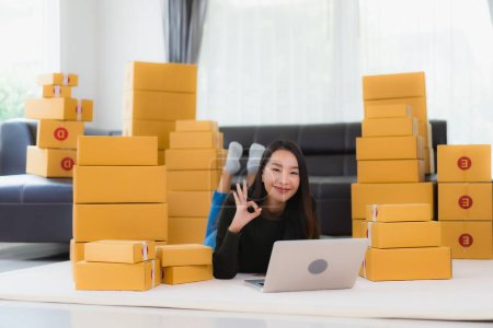 Photo for Portrait beautiful young asian woman work at home and prepare cardboard box packaging ready for online shipping - Royalty Free Image