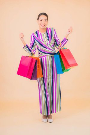 Téléchargez les photos : Portrait belle jeune femme asiatique avec sac à provisions coloré sur fond isolé couleur - en image libre de droit