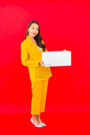 Téléchargez les photos : Portrait belle jeune femme asiatique avec boîte en carton prêt pour l'expédition - en image libre de droit