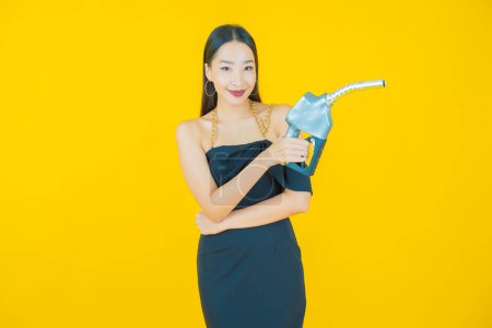 Téléchargez les photos : Portrait belle jeune asiatique femme querelle pompe à essence sur fond de couleur - en image libre de droit