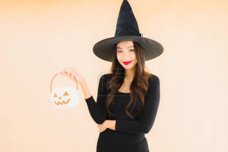 Téléchargez les photos : Portrait belle jeune femme asiatique porter costume d'Halloween sur fond isolé couleur - en image libre de droit