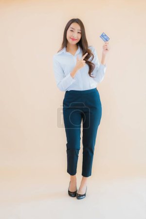 Téléchargez les photos : Portrait belle jeune femme asiatique d'affaires avec téléphone et carte de crédit sur fond isolé couleur - en image libre de droit