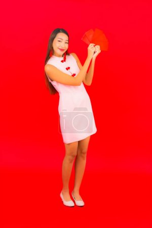Foto de Retrato hermosa joven mujer asiática con sobre rojo letra sobre fondo rojo - Imagen libre de derechos