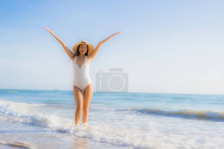 Téléchargez les photos : Portrait belle jeune femme asiatique sourire heureux autour de la mer océan plage et ciel bleu pour les vacances de voyage de loisirs - en image libre de droit