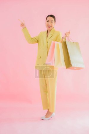 Foto de Retrato hermosa joven mujer de negocios asiática con bolsa de compras en color aislado fondo - Imagen libre de derechos