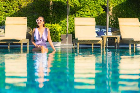 Téléchargez les photos : Portrait belle jeune femme asiatique relax sourire loisirs sur les vacances autour de la piscine en hôtel station balnéaire - en image libre de droit