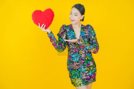 Photo for Portrait beautiful young asian woman smile with heart pillow shape on color background - Royalty Free Image