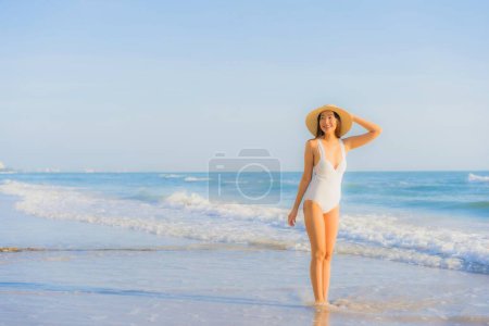 Foto de Retrato hermosa joven asiática mujer feliz sonrisa alrededor de mar océano playa y azul cielo para vacaciones de ocio - Imagen libre de derechos