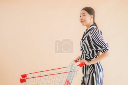 Foto de Retrato hermosa joven asiática mujer con carrito de la compra de comestibles - Imagen libre de derechos