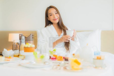 Photo for Portrait beautiful young asian woman enjoy breakfast on bed in bedroom interior - Royalty Free Image