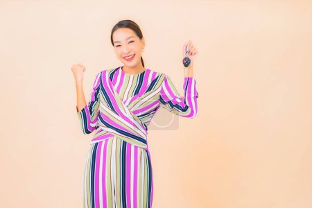 Foto de Retrato hermosa joven asiática mujer mostrar coche llave en color fondo - Imagen libre de derechos