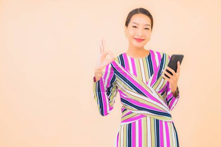 Foto de Retrato hermosa joven asiático mujer uso inteligente móvil en color aislado fondo - Imagen libre de derechos